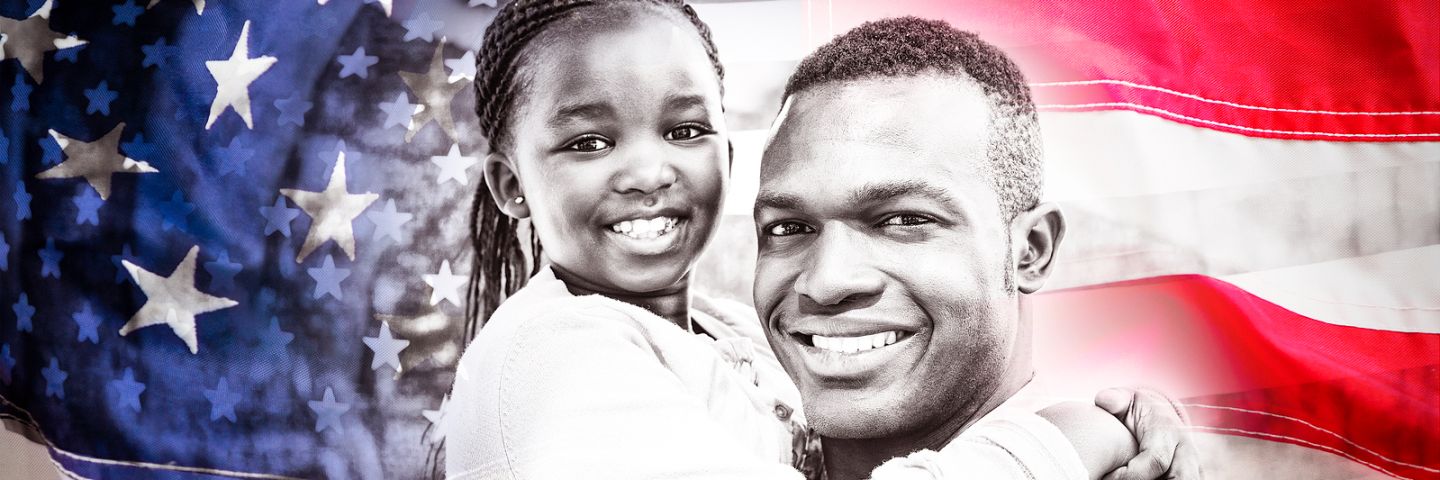 Father and daughter in front of flag